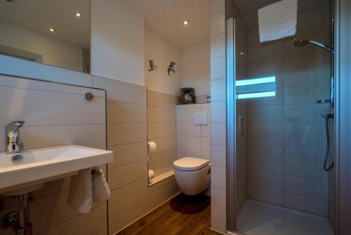 a bathroom with a shower and a sink and a toilet at Ferienwohnung am Meer in Markgrafenheide