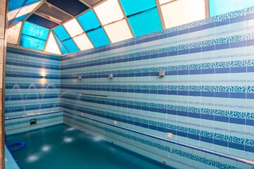 a swimming pool with blue and white tiled walls and windows at Rabigh Tower Hotel in Rabigh