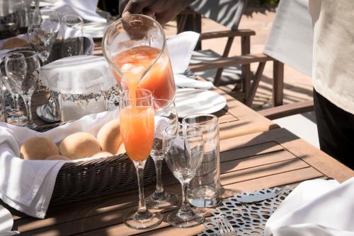 a table with two wine glasses and a basket of bread at Olarro Plains in Masai Mara