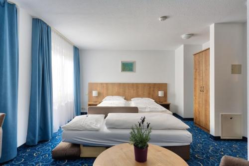 ジンデルフィンゲンにあるAppartis - Hotel am Stadtparkのベッド2台とテーブルが備わるホテルルームです。