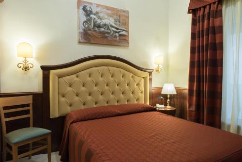 - une chambre avec un lit doté d'un couvre-lit rouge dans l'établissement Domus Augusta, à Rome