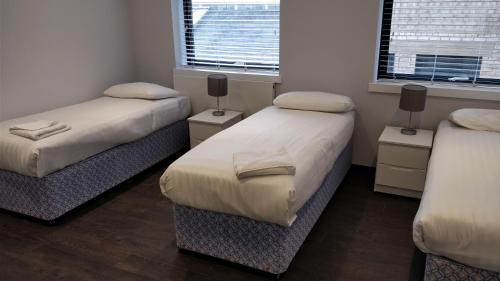 a room with two beds and two windows at Access Tower Hill in London