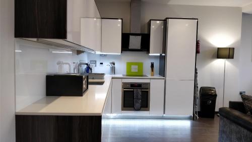 a kitchen with white cabinets and a stove at Access Tower Hill in London