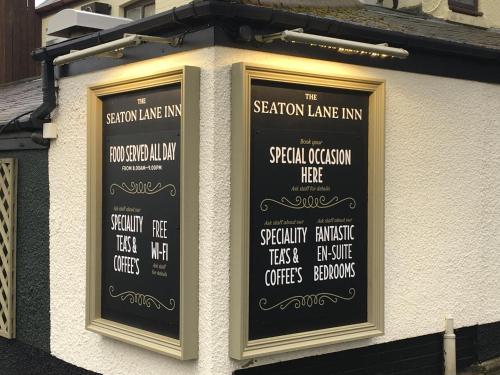 two black signs on the side of a building at The Seaton Lane Inn - The Inn Collection Group in Seaham