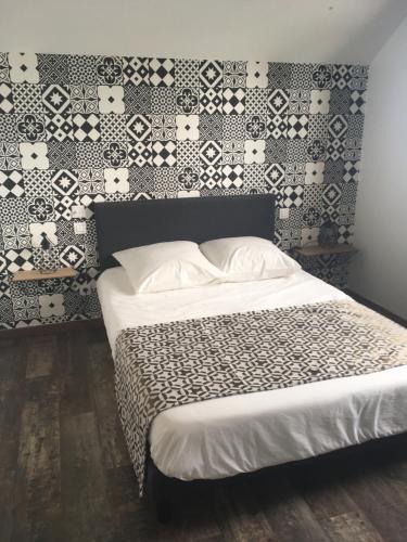 a bedroom with a bed with a patterned wall at Caloupilé in Le Tampon