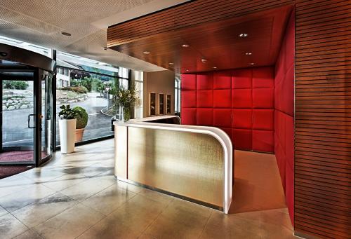 a lobby with a red wall in a building at Hotel Eden Spiez in Spiez