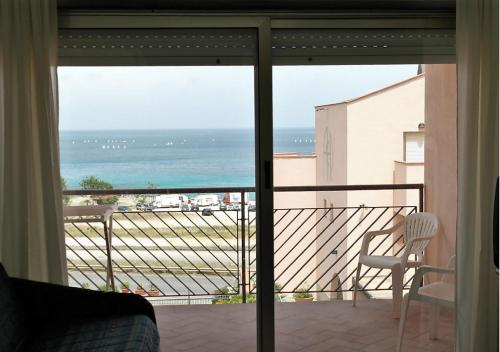 a bedroom with a view of the ocean from a balcony at Addaura Village e Congressi in Mondello