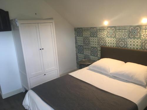 a bedroom with a white bed and a cabinet at Caloupilé in Le Tampon