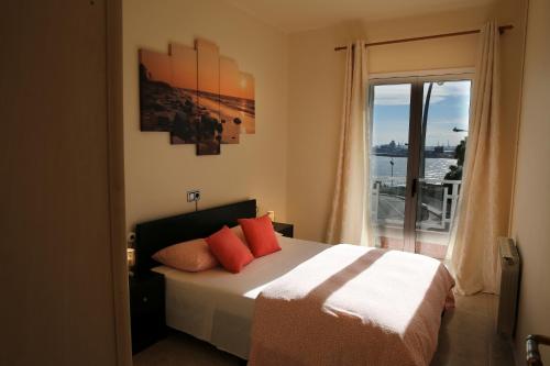 a bedroom with a bed with orange pillows and a window at Villa hortencia in Tarragona