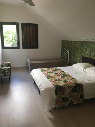 Un dormitorio con una cama grande y una ventana en Caloupilé, en Le Tampon