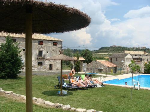 un grupo de personas sentadas en sillas de césped cerca de una piscina en Apartamento Sierra de Guara, en Paúles