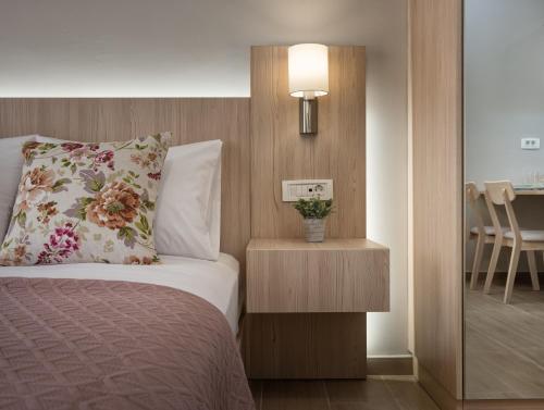 a bedroom with a bed with a flower pillow and a lamp at Katerina Studios in Tsilivi