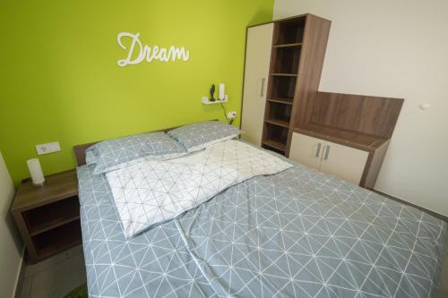 a bedroom with a bed and a green wall at Apartma Mariposa Banovci in Banovci