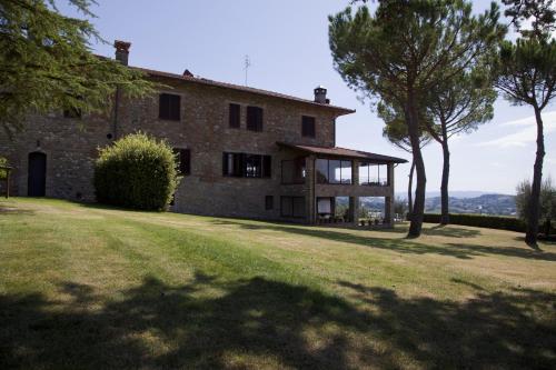 an old stone house on a field with trees at Agriturismo San Fedele in Perugia