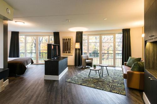 a hotel room with a bed and a television at Fletcher Landgoed Hotel Holthurnsche Hof in Berg en Dal
