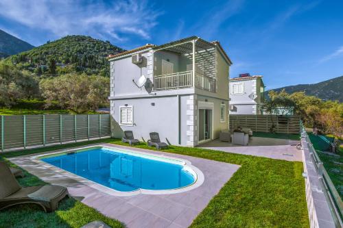 a house with a swimming pool in the yard at Abeli Villas in Nydri