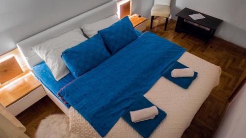 a large bed with blue sheets and pillows on it at Zen Voyage in Zagreb