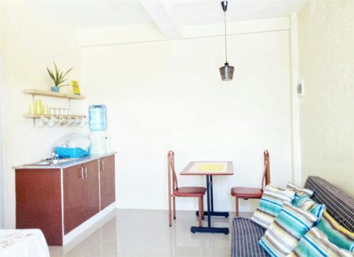 a kitchen with a table and chairs and a table at R & D Island Lodge in Bantayan Island