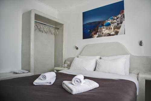 ein Schlafzimmer mit einem Bett mit Handtüchern darauf in der Unterkunft Corrado Caldera Apartments in Fira