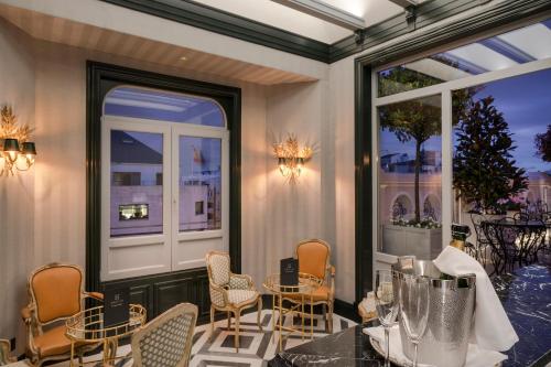 a patio with a table and chairs and windows at Relais & Châteaux Heritage Hotel in Madrid