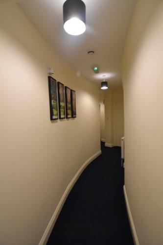 a hallway in an office with paintings on the wall at King's Cross Quiet Apartment in London