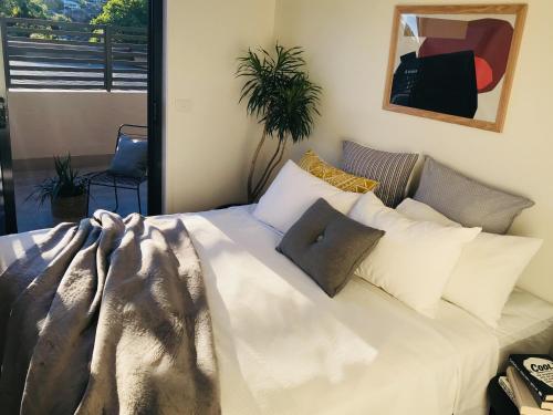 ein Schlafzimmer mit einem großen weißen Bett mit Kissen in der Unterkunft The Botanical 201 in Albury