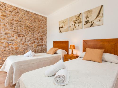 LlombartsにあるFinca Ses Comesの石壁の客室で、ベッド2台が備わります。
