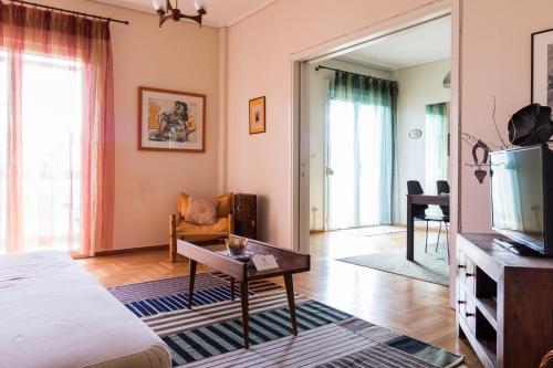 sala de estar con cama y TV en Two-Bedroom Apartment -Kallirrois Athens, en Atenas