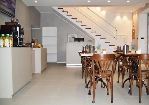 a restaurant with tables and chairs and a staircase at Hotel Il Loggiato Dei Serviti in Como