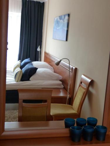 a bedroom with a bed and a chair and a mirror at Apartament Grażyna in Krynica Zdrój