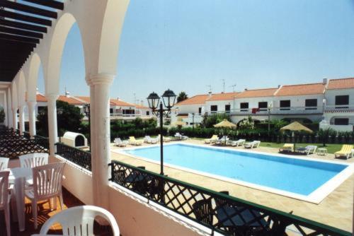 a beach with a pool and a balcony at Apartamentos Turisticos Alagoa Praia in Altura