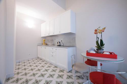 a kitchen with white cabinets and a table at DieciSedici in Amalfi