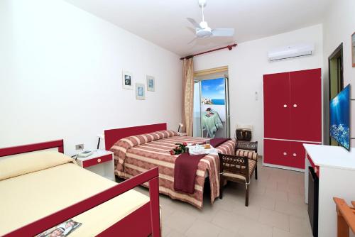 una camera d'albergo con letto e soggiorno di Hotel Peschici a Peschici