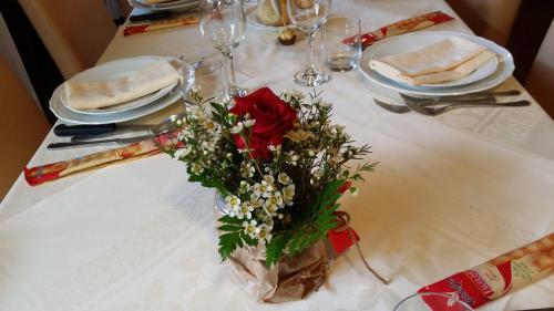 a table with a vase of flowers on a table at Albergo Sapori in Tolè