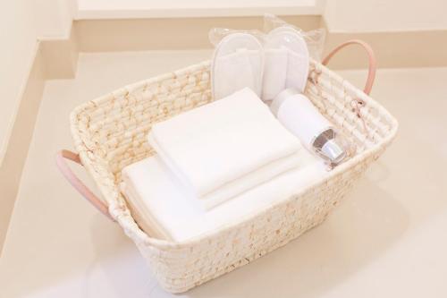 uma cesta cheia de toalhas e produtos de higiene pessoal num piso em Shin-Okubo City Hotel em Tóquio
