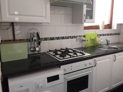 Il comprend une cuisine équipée d'une cuisinière et d'un comptoir. dans l'établissement Hooton Apartment 1 bed, à Kilnhurst
