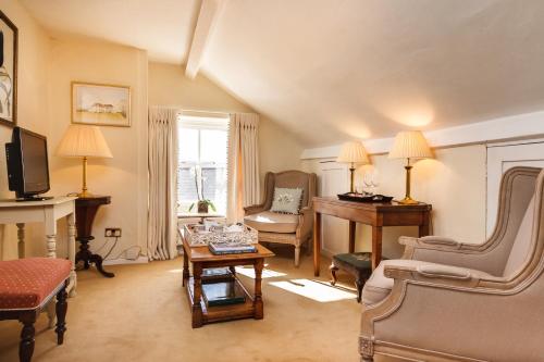 a living room with a table and a piano at Newton Cottage in Porthcawl