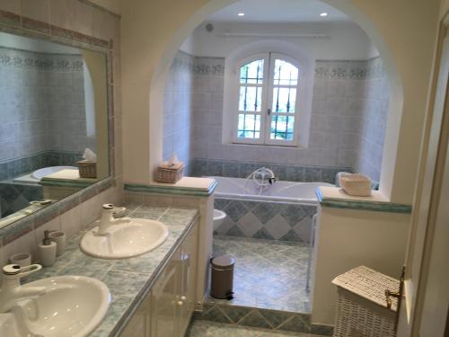 a bathroom with two sinks and a tub at Le Champmazet in La Roquette-sur-Siagne