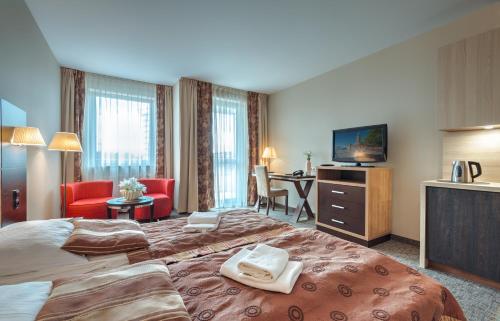 a hotel room with two beds and a television at Apartamenty Diva Kołobrzeg in Kołobrzeg