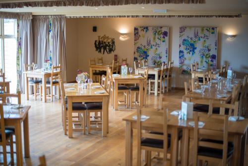 a dining room with wooden tables and chairs at The Poltimore Inn in North Molton