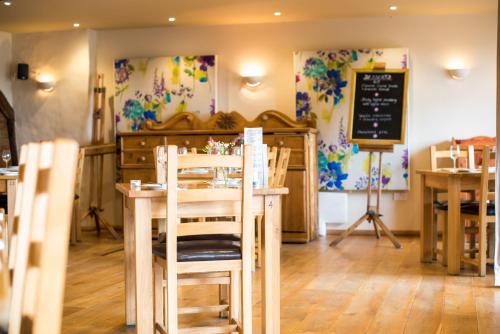 a restaurant with a table and chairs and a chalkboard at The Poltimore Inn in North Molton