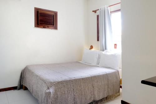 a bedroom with a bed in a white room at Hotel e Pousada La Dolce Vita in Canoa Quebrada