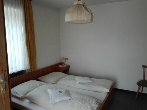 two twin beds in a room with a window at Hotel Haselried in Tirolo