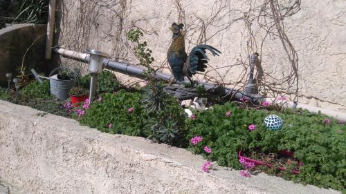 a statue of a bird sitting in a garden at Auberge La Folie in Sausset-les-Pins