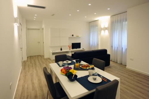 a room with a table and chairs and a living room at RivAppartamenti in Riva del Garda
