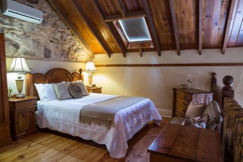 1 dormitorio con 1 cama y suelo de madera en Clare Valley Heritage Retreat, en Clare