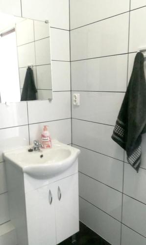 a white bathroom with a sink and a mirror at Walk distance to mokotow business park in Warsaw