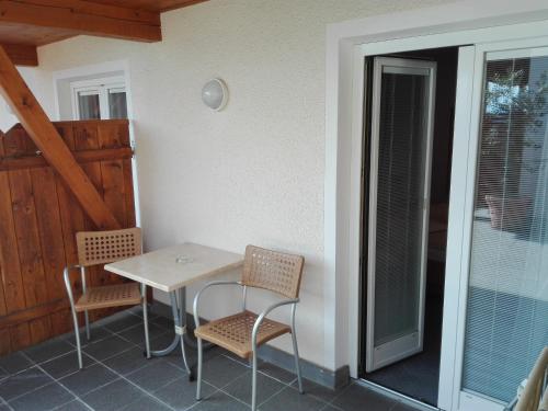 a table and chairs on the porch of a house at Hotel Haselried in Tirolo