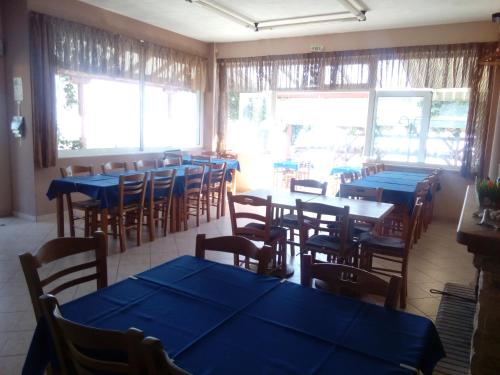 a restaurant with blue tables and chairs and windows at Delfini in Akhladherí