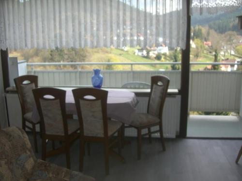 a table with chairs and a vase on top of a balcony at Ferien Penthouse Panoramablick oder Studio Panoramablick in Bad Grund